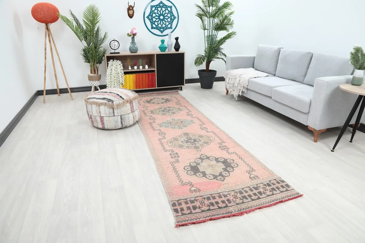 Angle view of the rose runner rug in a room, highlighting its placement between furniture.