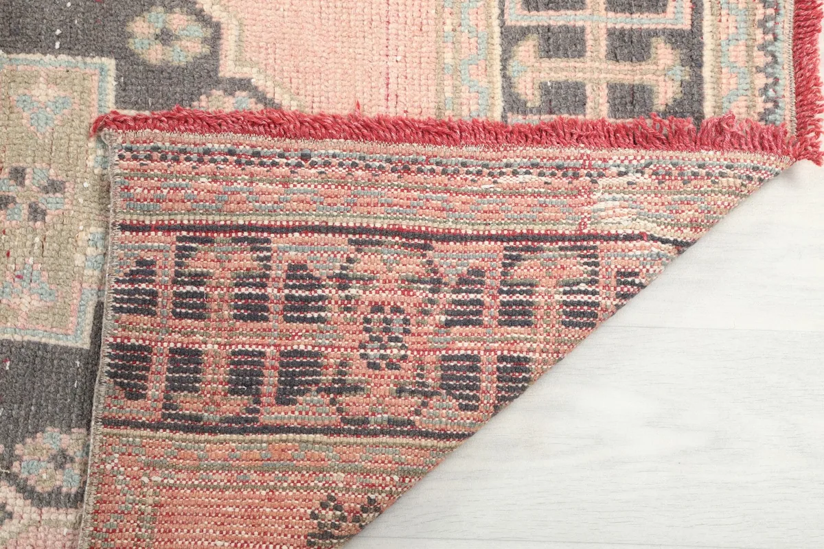 Detail of the rug's reverse side, showcasing the intricate hand-knotted wool pile on cotton foundation.