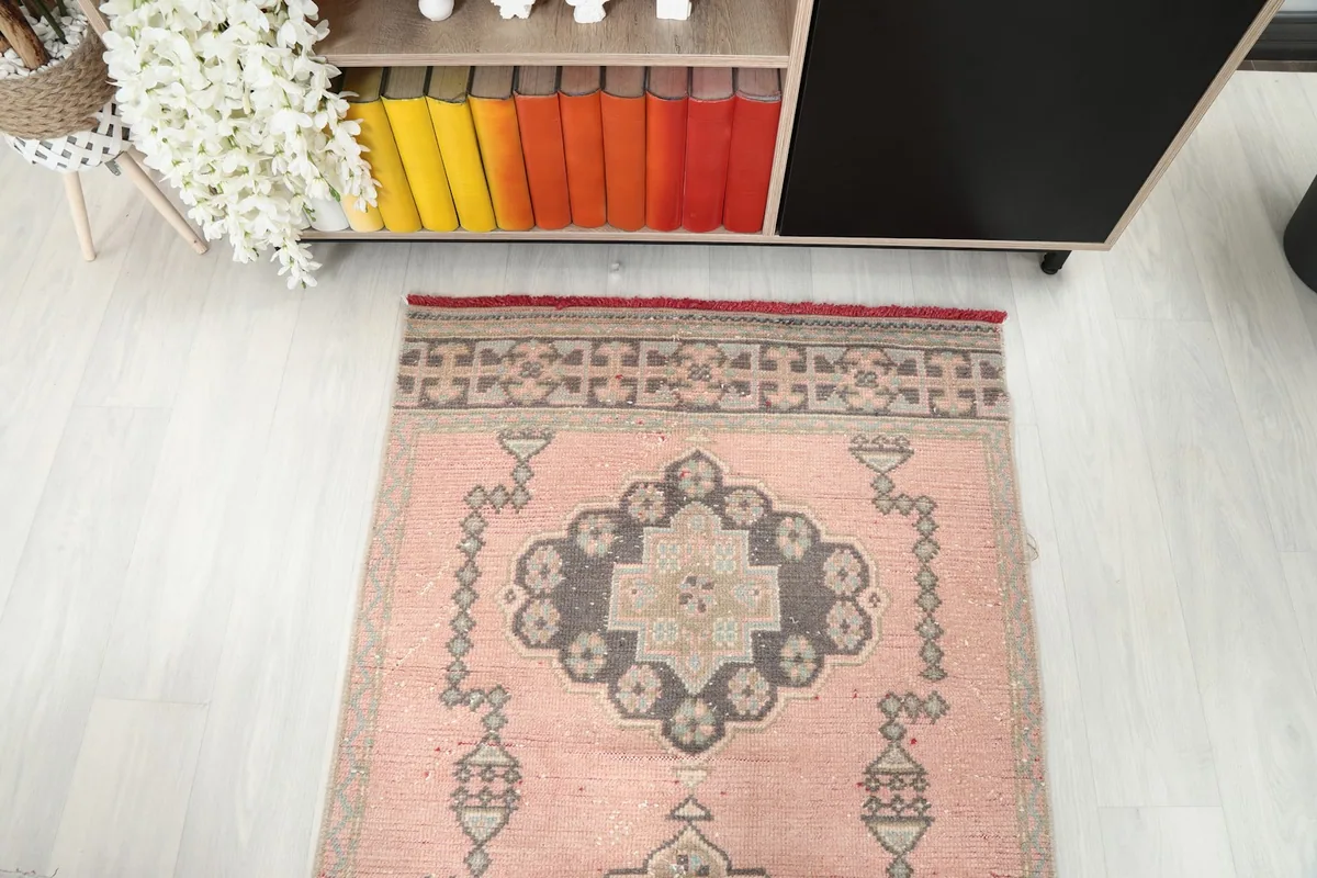 Overhead view of one end of the rose runner rug, showing the full width and border pattern.