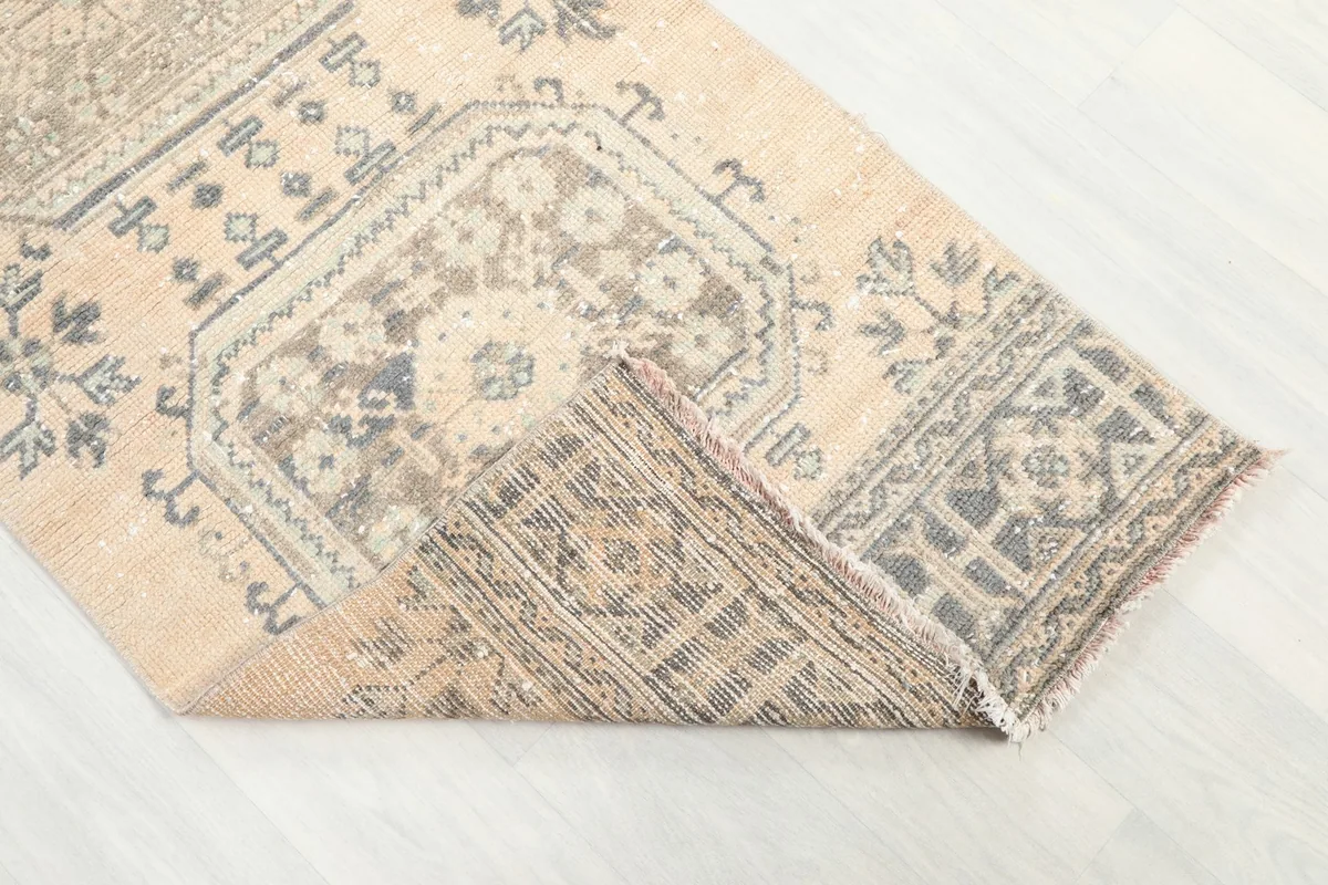 Folded corner of the rug, revealing the hand-knotted construction and wool pile on cotton foundation.