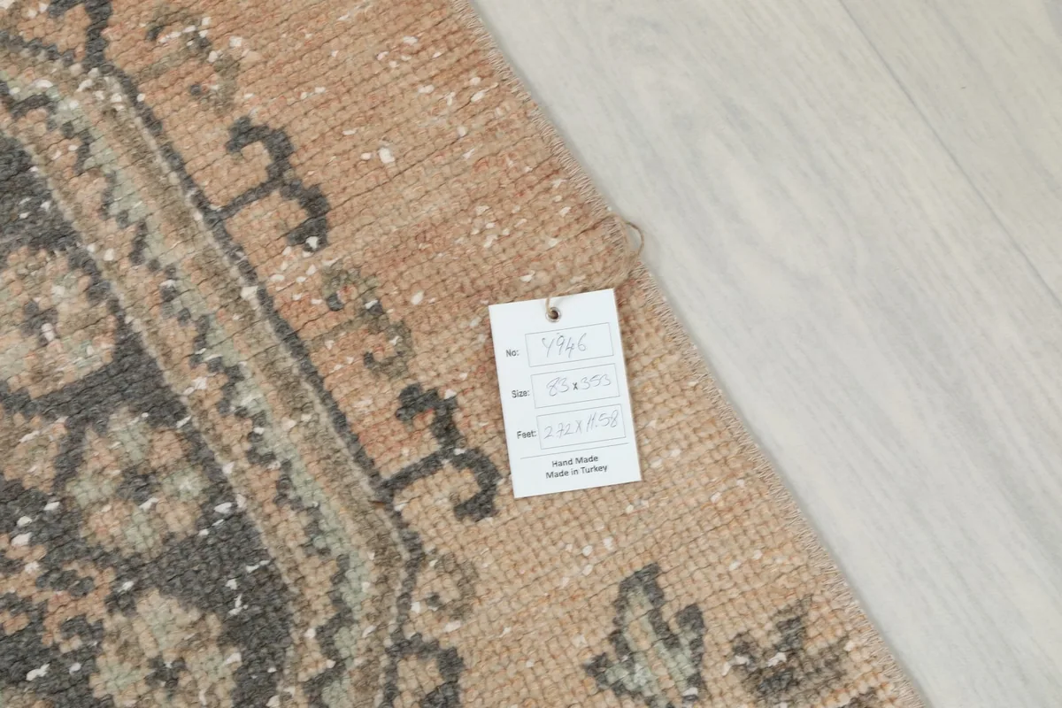 Corner of the rug with a product tag, displaying information about its origin and material.