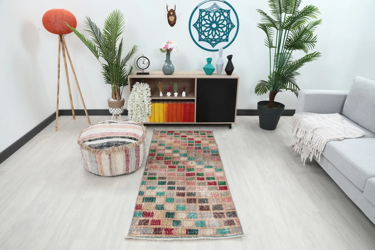 Multicolored runner rug in a modern living room setting with a light sofa and plants