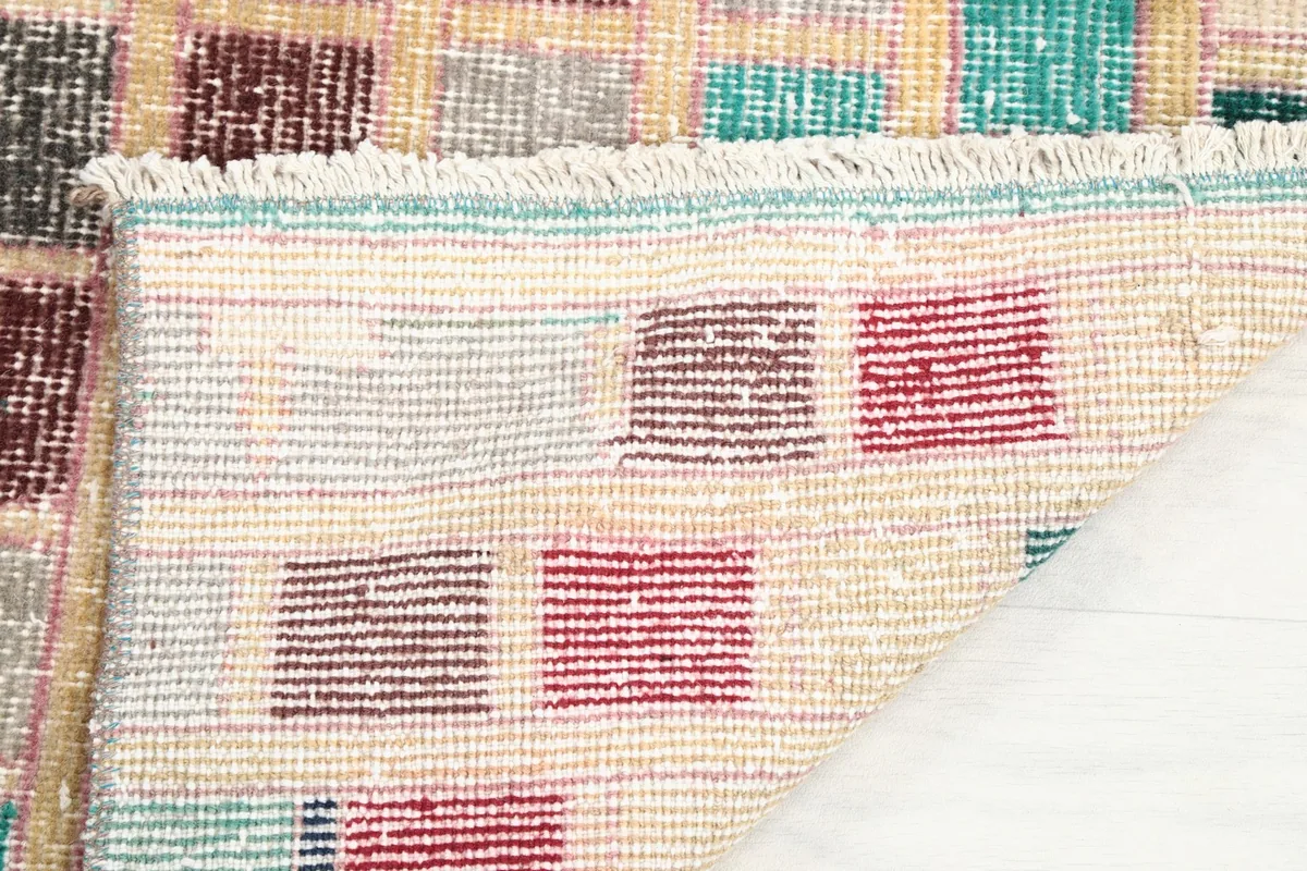 Close-up of the reverse side of the rug, showing the hand-knotted cotton foundation