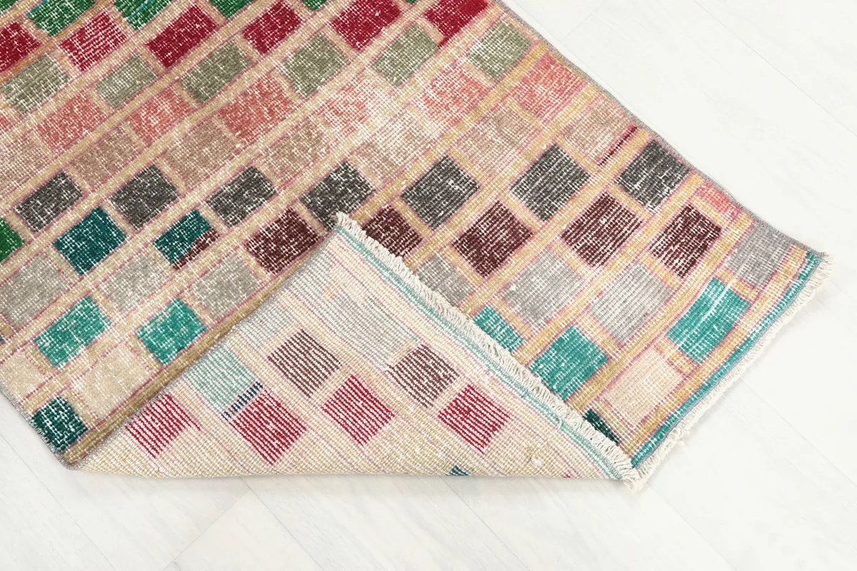 Folded corner of the rug revealing the wool pile and cotton foundation