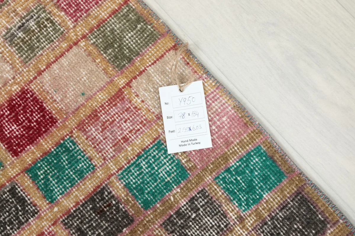 Detail of the rug's pattern with a product tag, showing its texture and colors