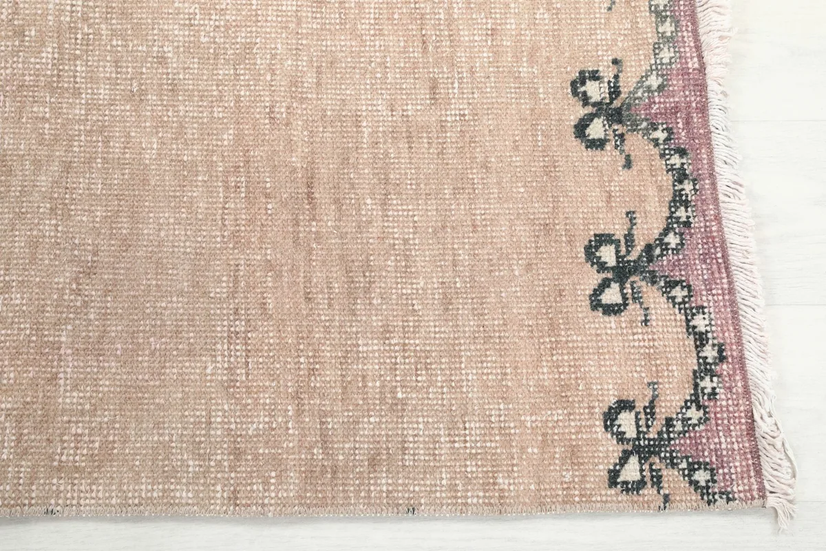 Detailed view of the runner's border pattern in rose and gray, showing the hand-knotted wool texture