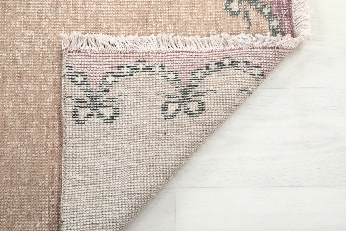 Close-up of the rug's reverse side, revealing the knotting and the cotton foundation material