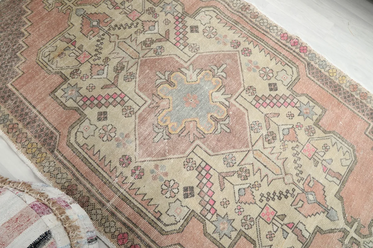 Overhead angle focusing on the rug's intricate central medallion and surrounding patterns, revealing varied colors.