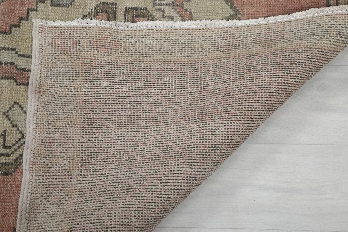 Close-up of the rug's back, revealing the tightly woven cotton foundation and the knot structure.
