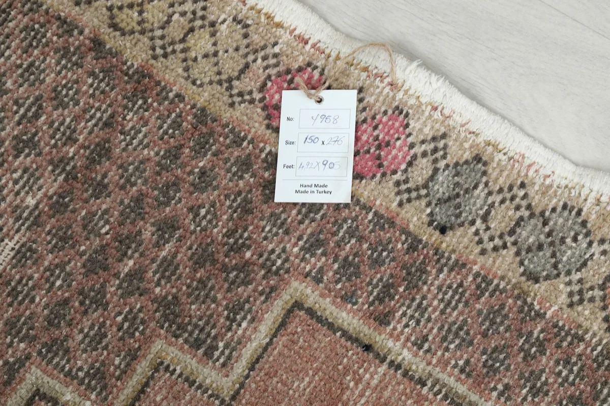 Detail of the rug's edge with a tag showing size information and origin, confirming it is hand-made in Turkey.