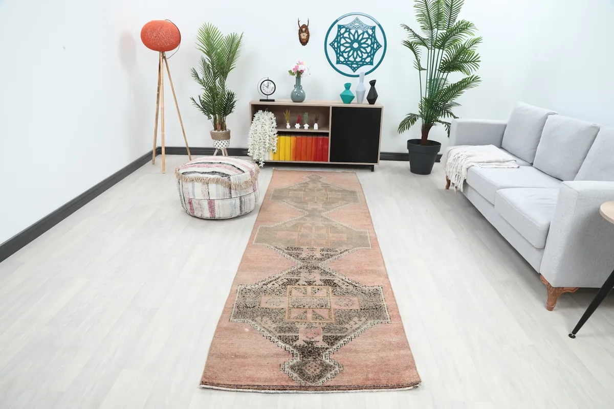 Vintage runner rug displayed in a bright modern hallway with plants and a sofa