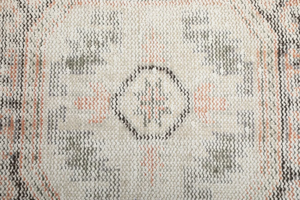 Close-up of the low wool pile, showing individual knots and the distressed appearance of the fibers