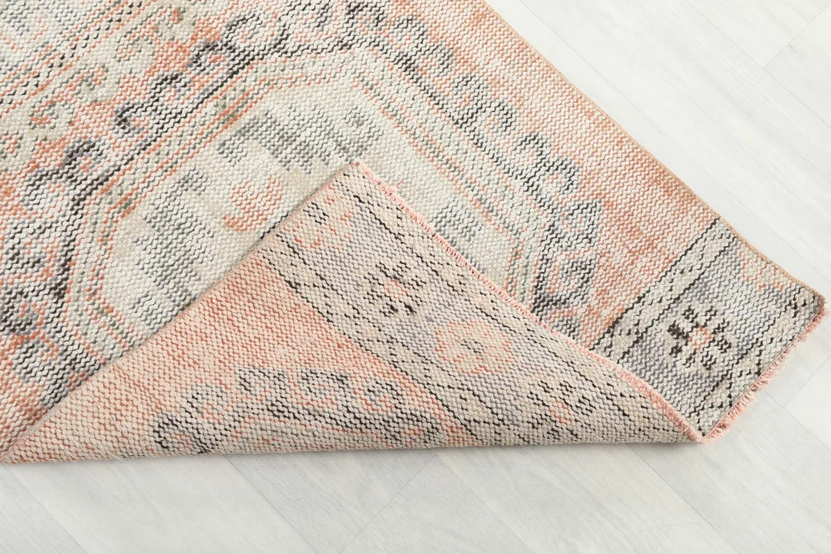 Folded corner of the rug, revealing the wool pile on cotton foundation and the reverse side