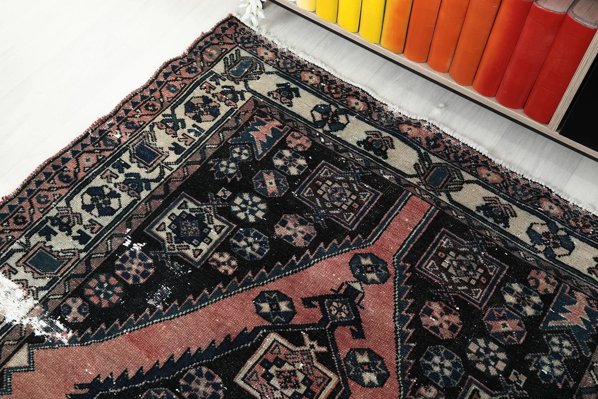 Corner view of the rug showcasing the border design and part of the black field