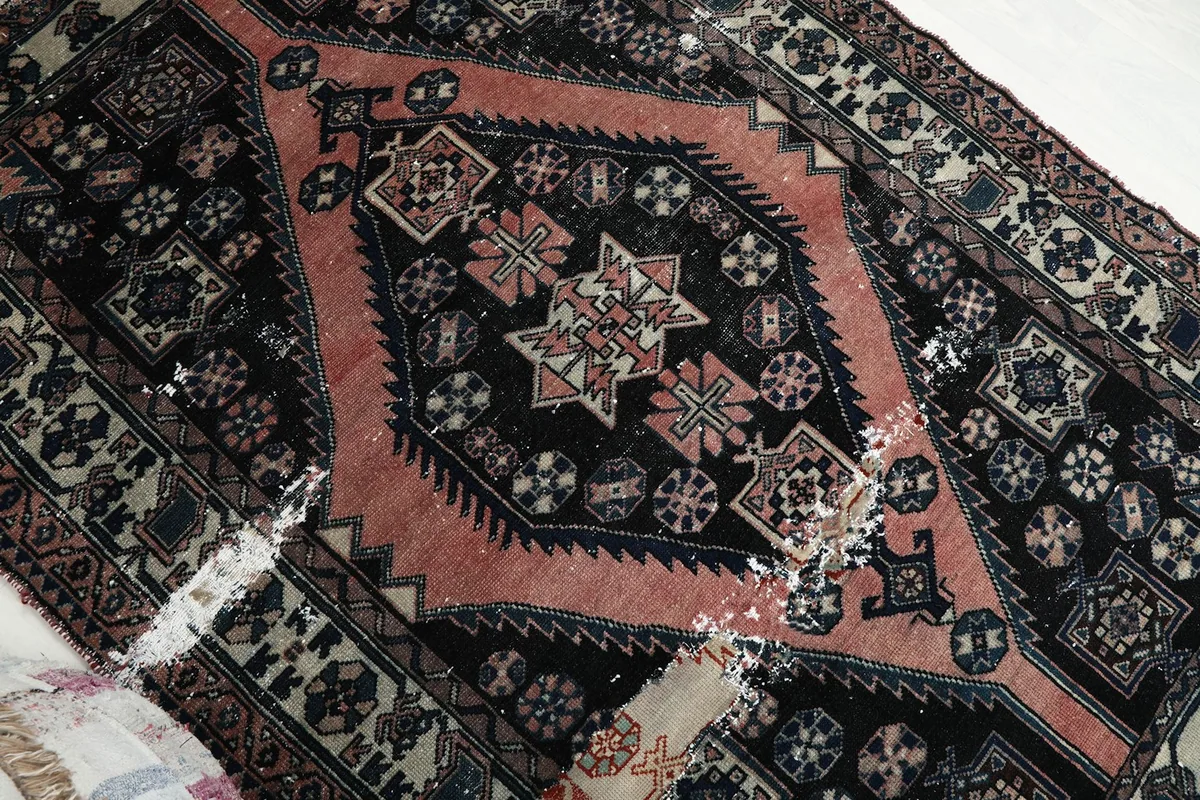 Overhead close-up of the central rose medallion and surrounding black field motifs