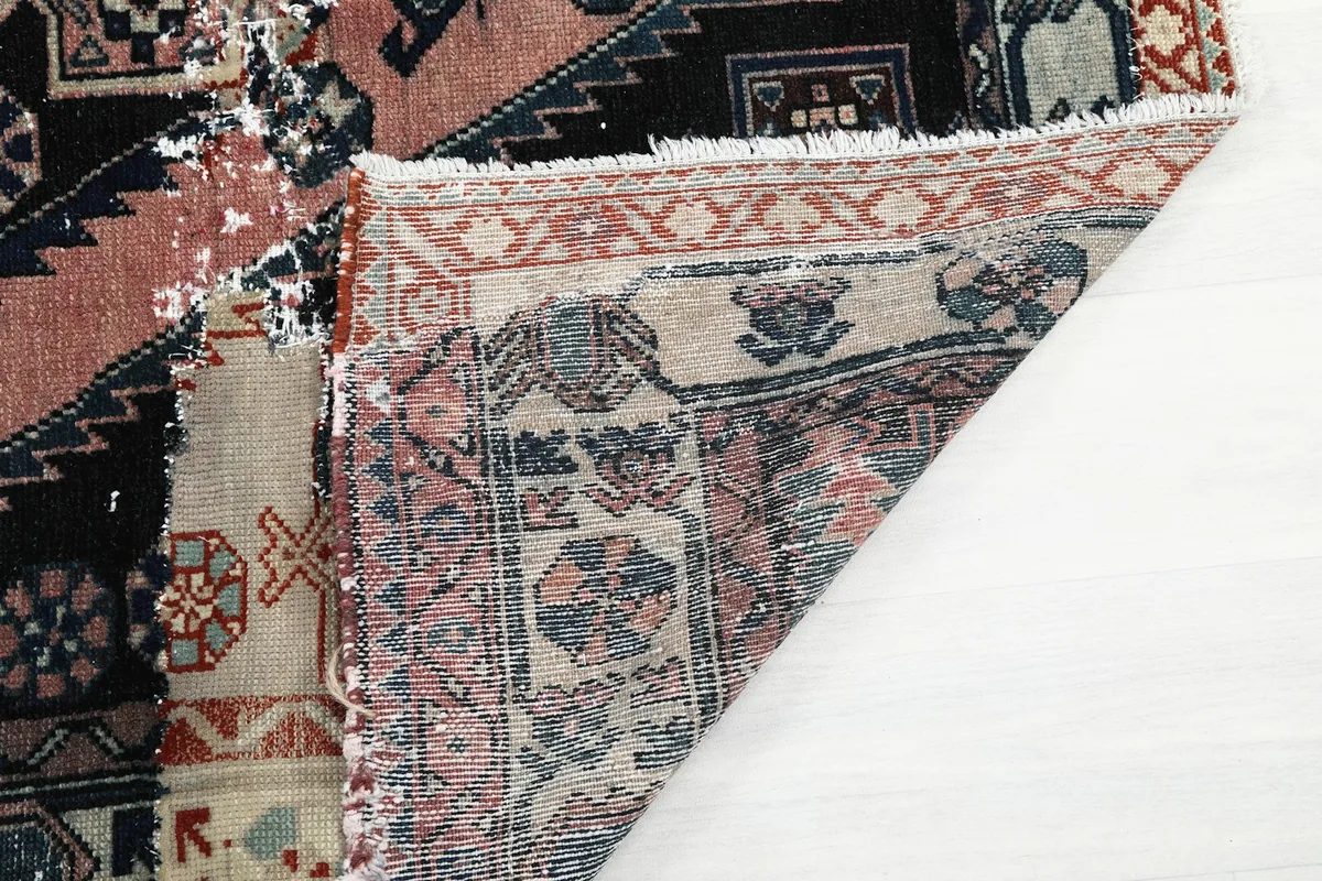 View of the back of the rug, showing the details of the hand-knotting and cotton foundation