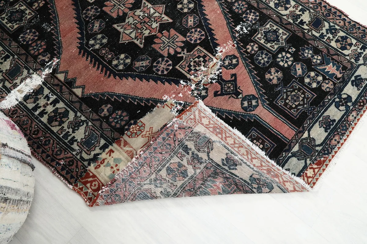 Folded corner of the rug revealing the reverse side of the hand-knotted cotton foundation