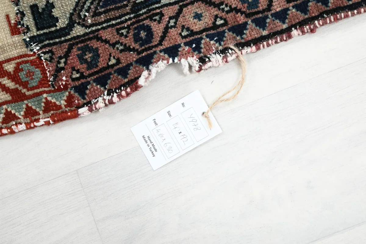 Close-up of the rug's edge with the product tag attached, showing construction details