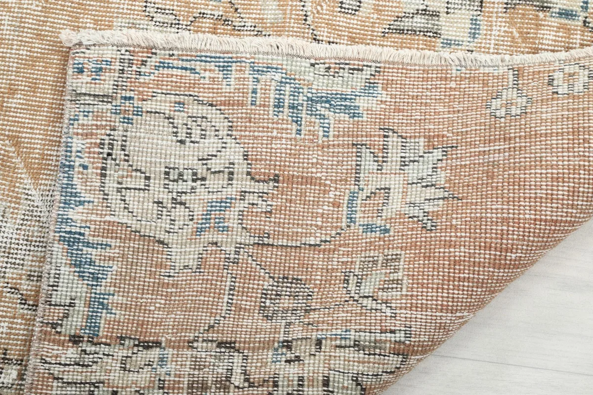 Underside view of the rug's corner, revealing the cotton foundation and fine hand-knotting craftsmanship