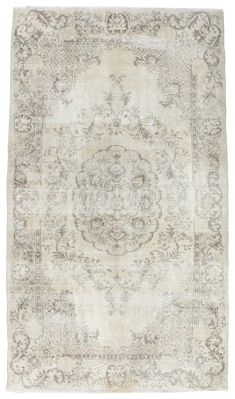 Full overhead view of a beige and gray vintage Anatolian area rug with a central medallion