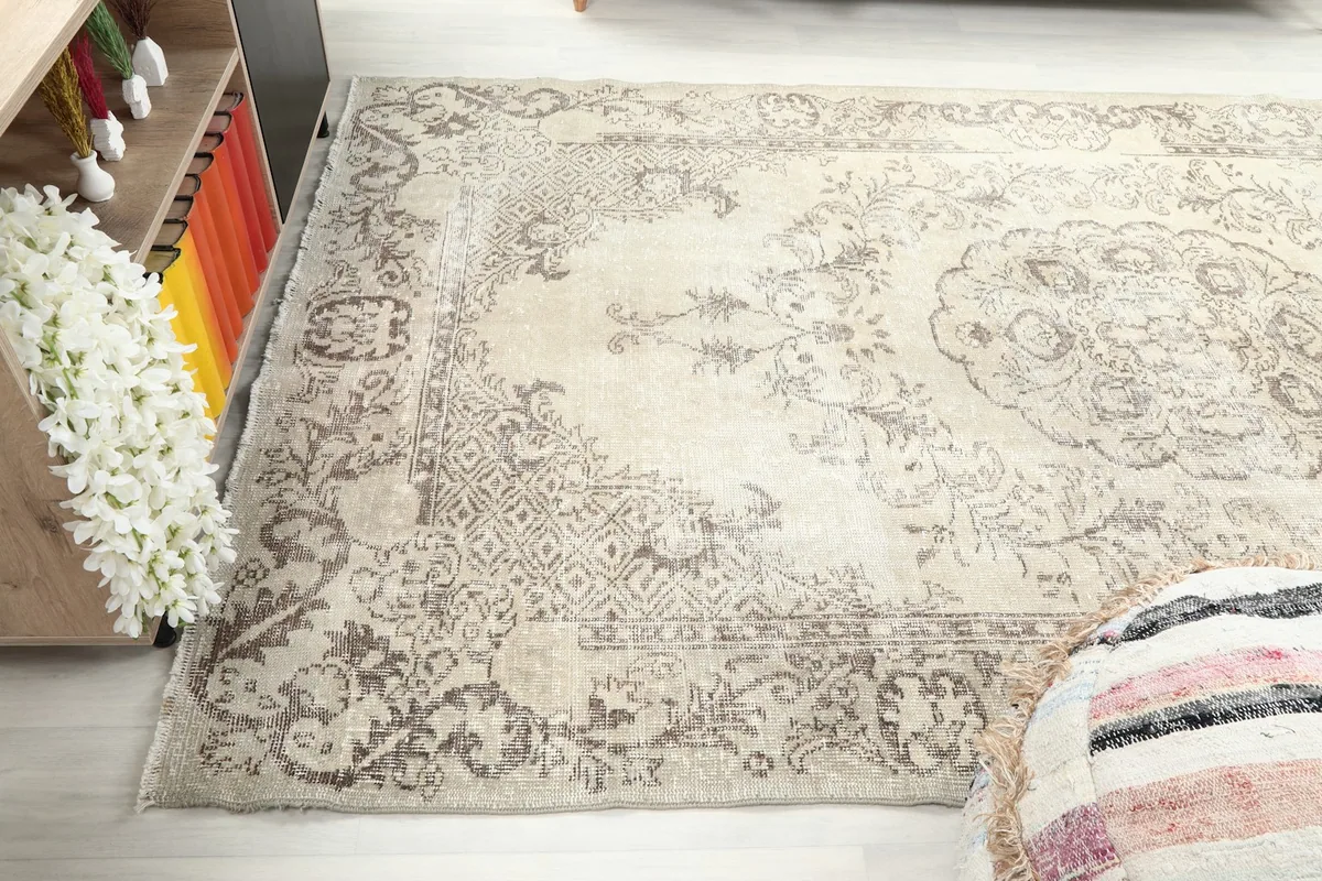 Side angle view capturing the full length of the beige and gray Anatolian rug in a room