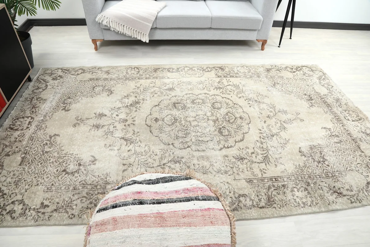 View of the beige and gray vintage rug from the end, showcasing its placement in a living area