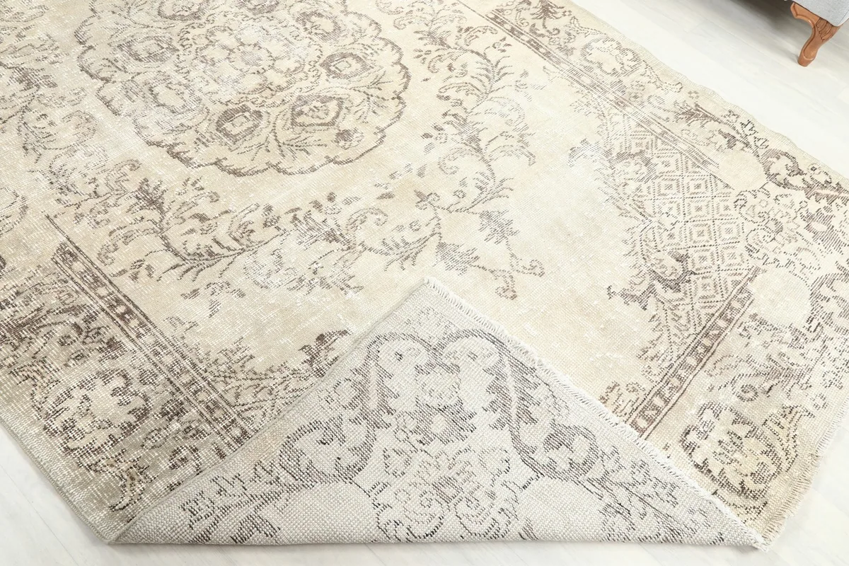 Corner of the rug folded back to show the hand-knotted wool pile and cotton foundation
