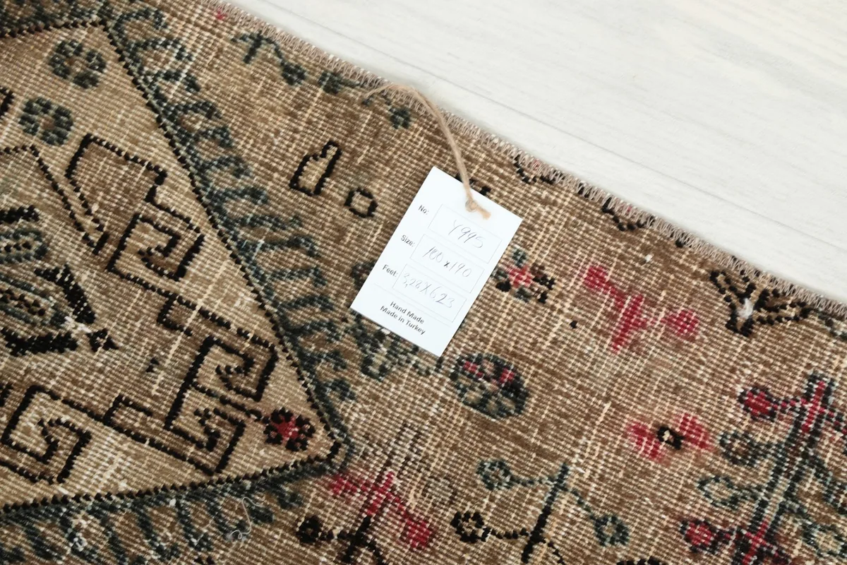 Close-up of the product tag attached to the vintage hand-knotted rug