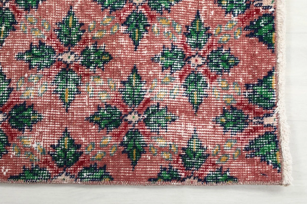 Detailed view of the hand-knotted wool pile and geometric design showing patina