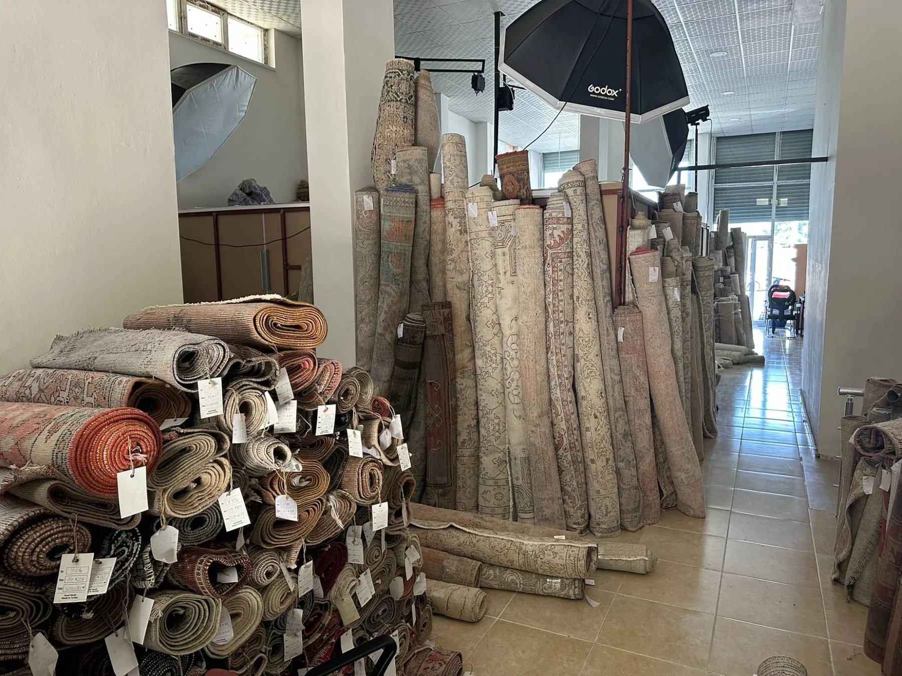Our warehouse of rolled vintage rugs and the photo studio where every rug is shot