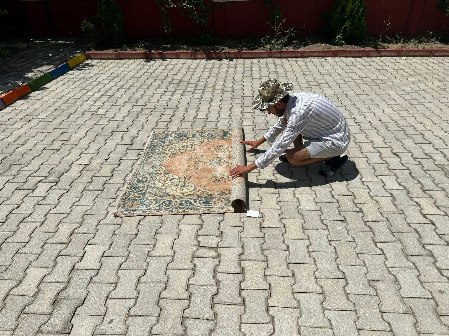 Unrolling a hand-knotted vintage rug in the sun